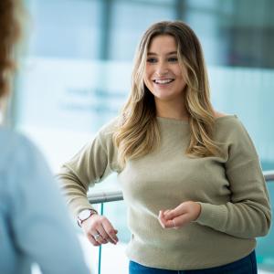 Female doctoral student in conversation on walkway